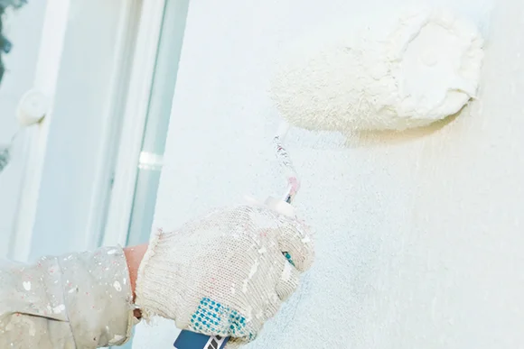 Person streicht Wand weiß